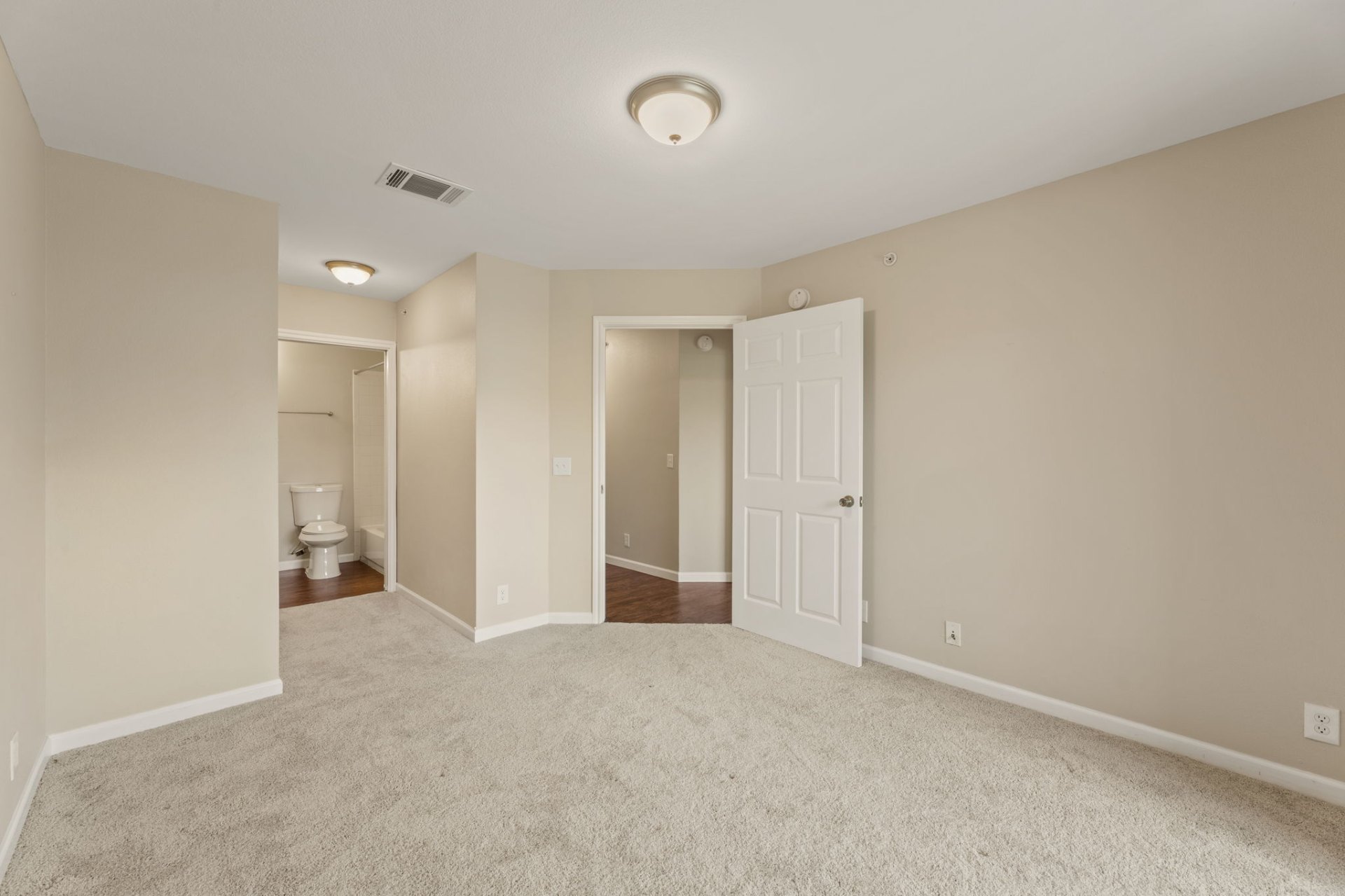 Primary bedroom with fresh carpet and en-suite bathroom access