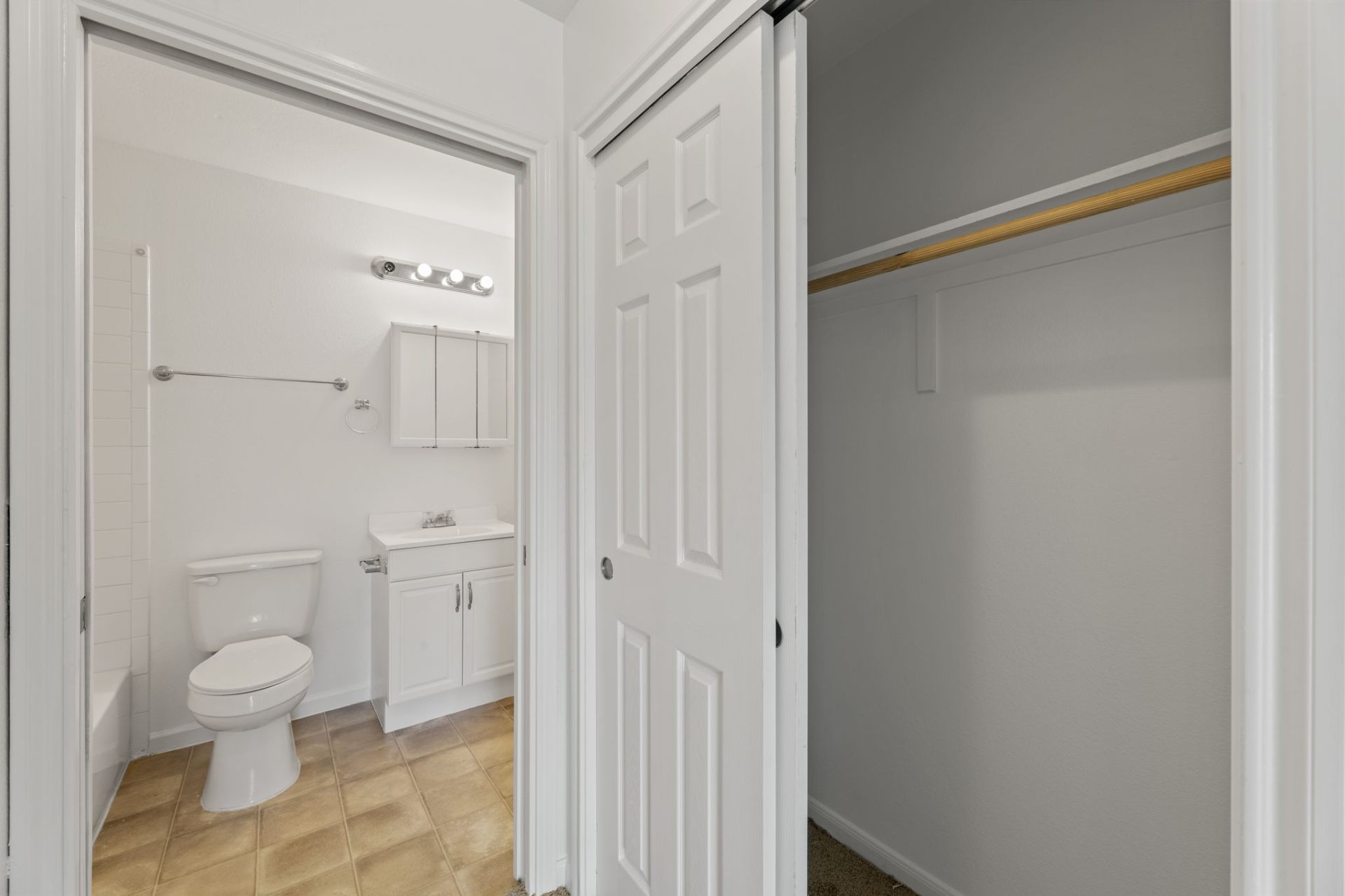 Classic-finish bathroom doorway next to a bedroom closet with sliding doors