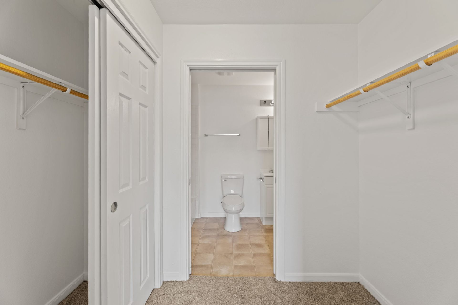 Classic-finish walk-through closet leading to the en-suite bathroom