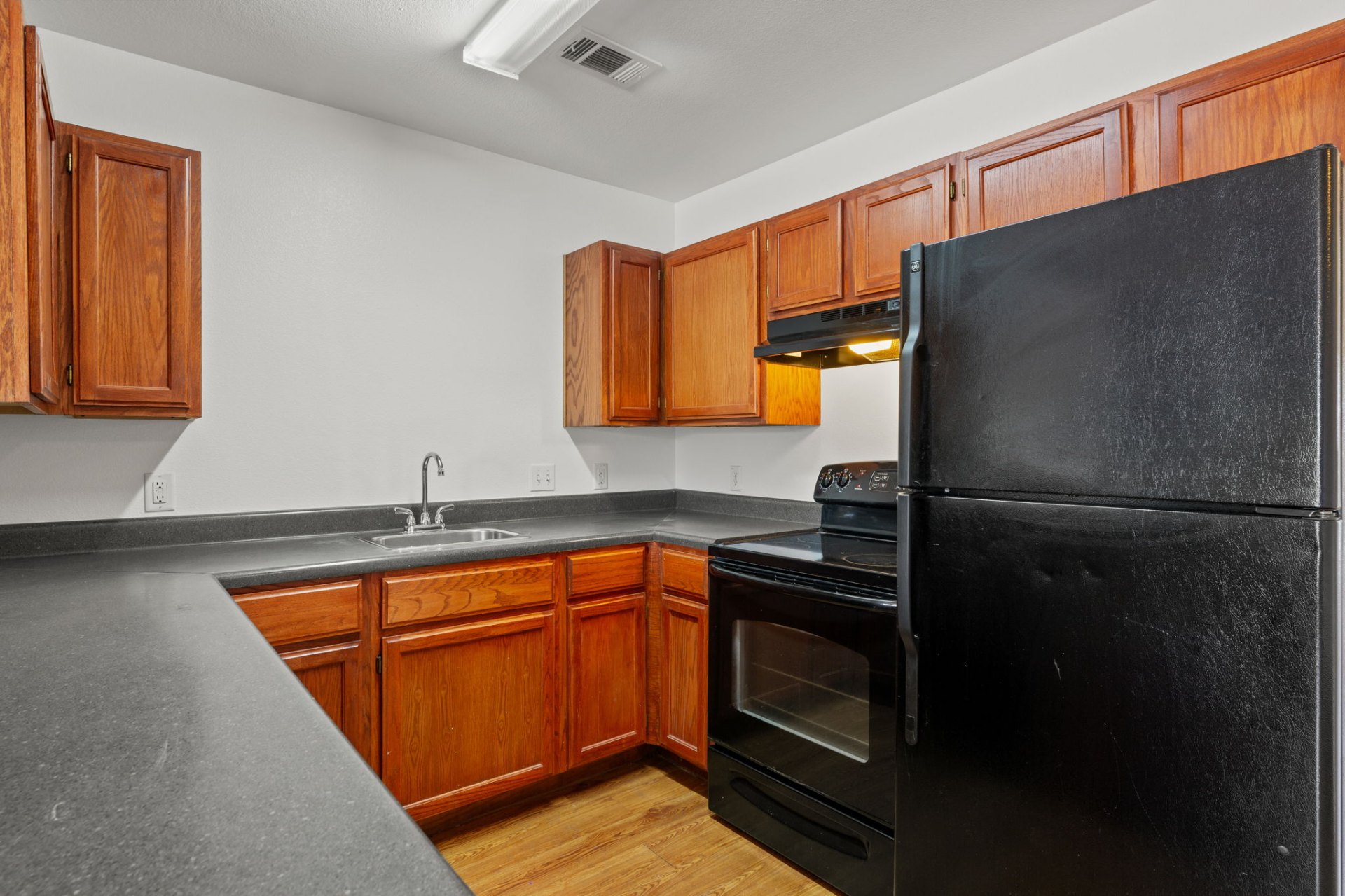 Classic-finish galley kitchen with oak cabinets and electric range