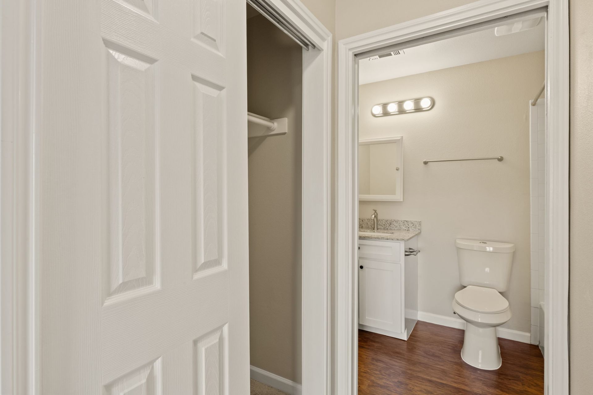 Closet and bathroom doorway with wood-look flooring